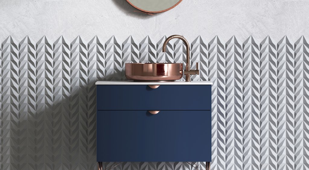 Armário de pia de banheiro com detalhes em azul ao lado de uma parede com revestimento Chevron estilo espinha de peixe.