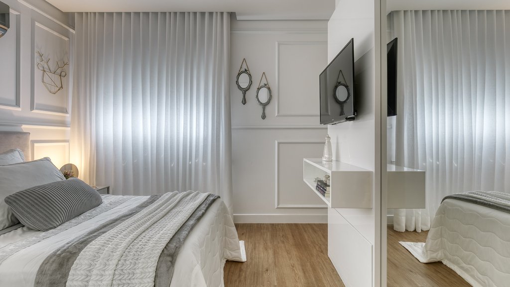 Truques para ampliar ambientes pequenos aplicados em um quarto decorado em tons de cinza.