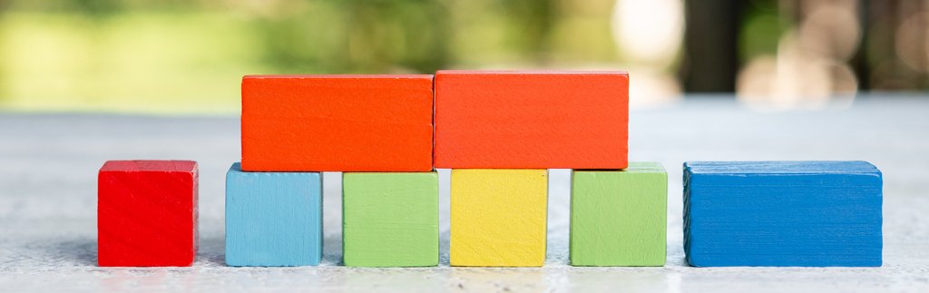 Imagem de pequenos pedaços de madeiras quadrados e retangulares coloridos, simbolizando a psicologia das cores na arquitetura.
