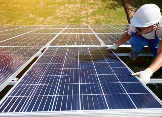 Homem instalando painéis solares para colocar em prática a energia fotovoltaica