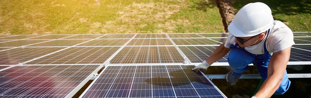 Homem instalando painéis solares para colocar em prática a energia fotovoltaica.
