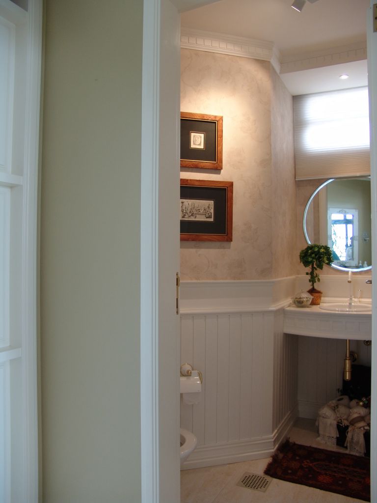 A imagem mostra um banheiro do quarto de um hotel com lambri.