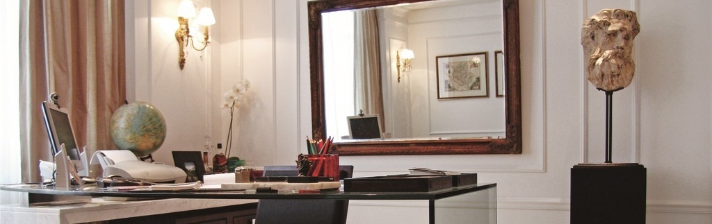 imagem mostra sala com espelho, mesa e cadeira.