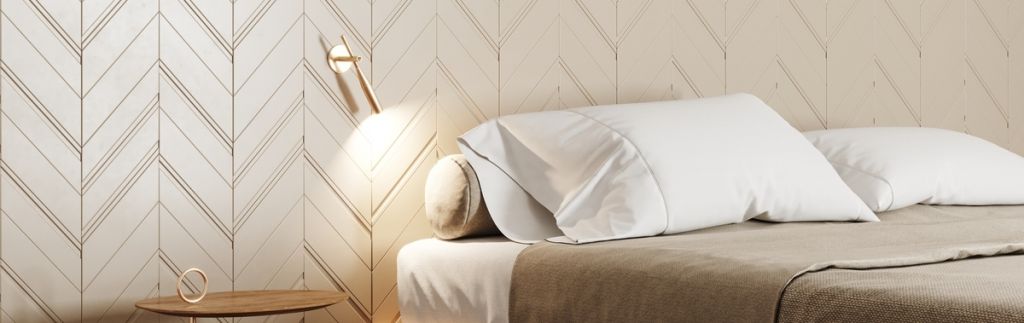 Revestimento Chevron branco aplicado na decoração de um quarto com cama de casal.