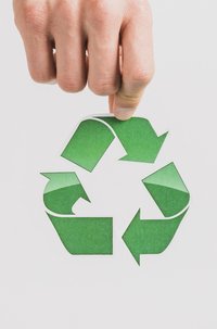 Mão segurando símbolo de reciclagem para reforçar o ESG em construções civis.