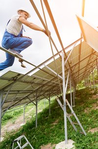 Homem instalando painéis solares para gerar energia fotovoltaica.