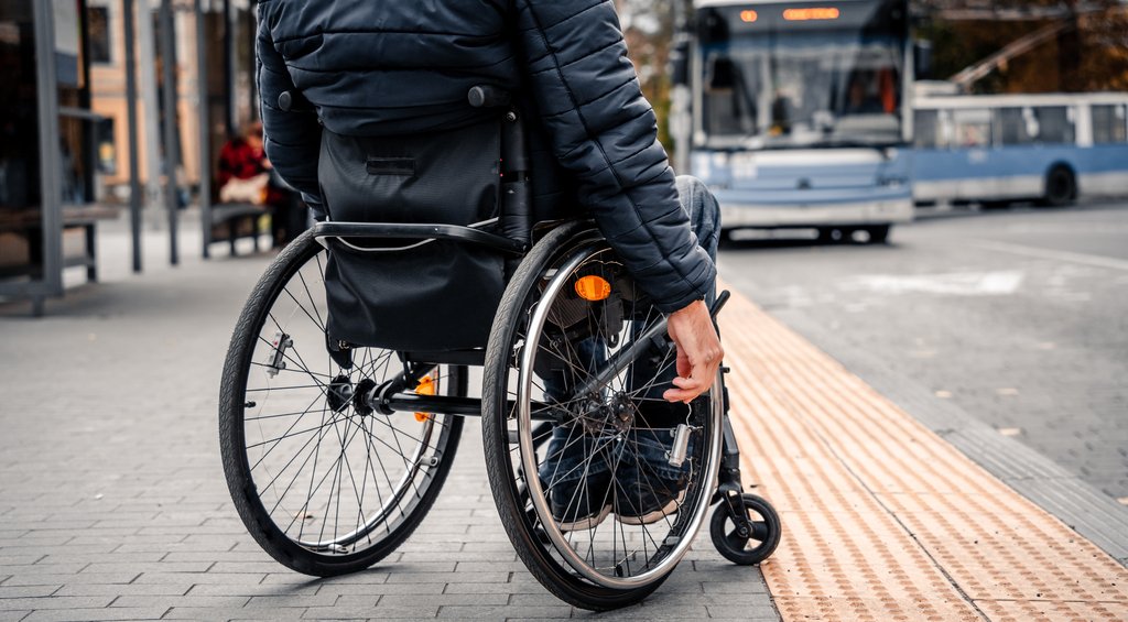 Homem utilizando cadeira de rodas em calçada simbolizando a arquitetura inclusiva