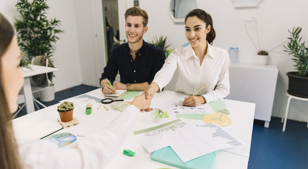 Pessoas realizando acordos para certificação ISO 14001.