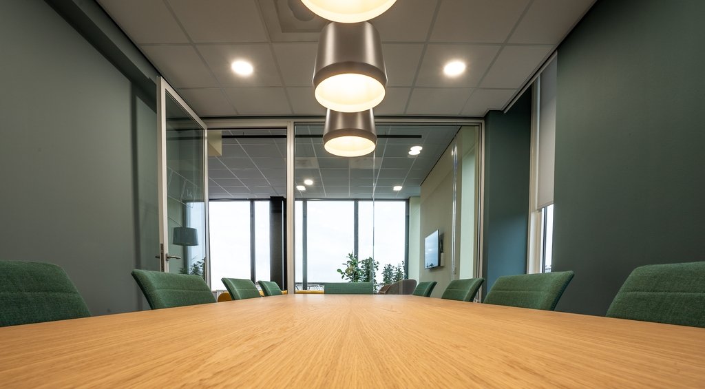 Sala de reuniões em escritório simbolizando os tipos de divisória de ambiente com exemplo na foto em vidro e metal.
