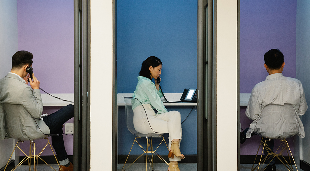 Espaço de coworking com cabines individuais, e acabamentos que complementam a decoração.