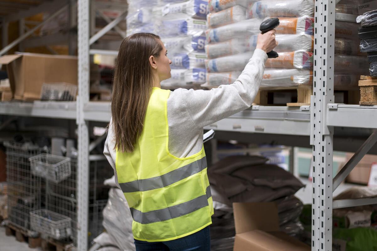 Funcionária fazendo a leitura de mercadorias armazenadas em estoque