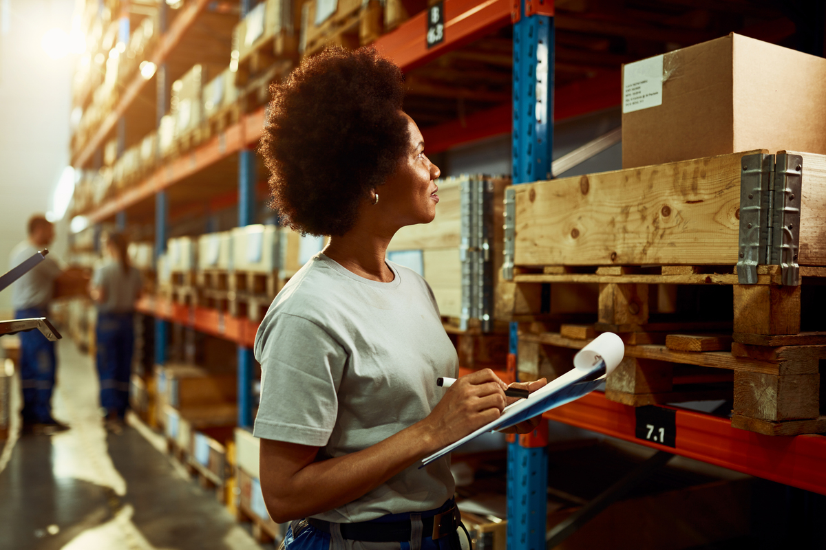 Funcionária fazendo o inventários das mercadorias armazenadas em estoque