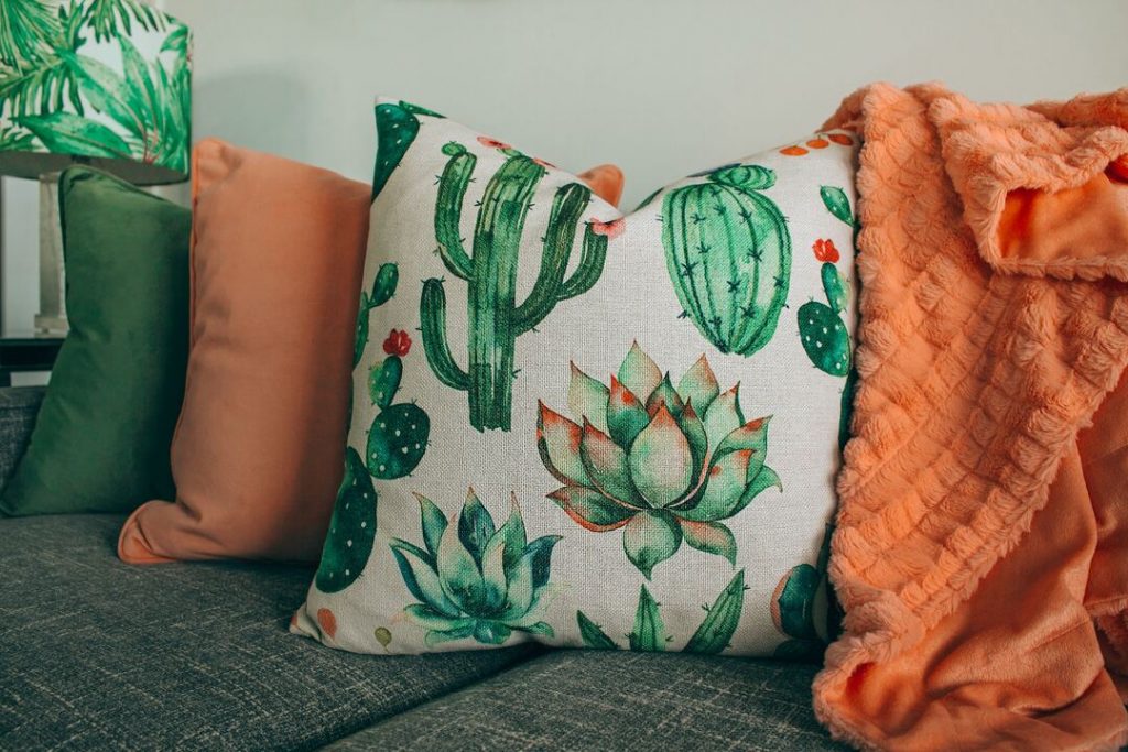 sofá com almofadas de estampas de cactos com decoracao cottagecore