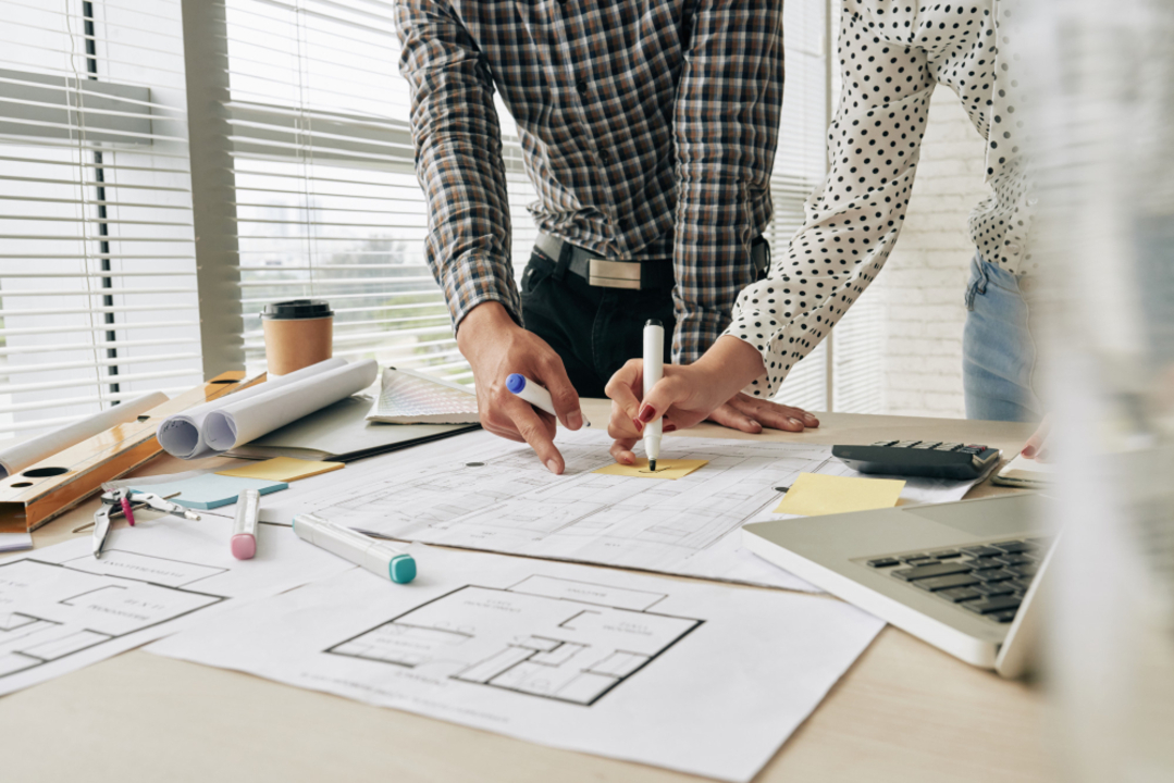 Arquitetos analisando a planta de uma construção